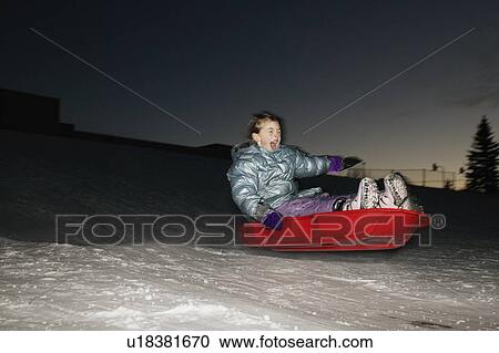 Stock Image - Child in sled at night. Fotosearch
