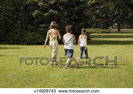 Stock Image - Family walking in the park. Fotosearch