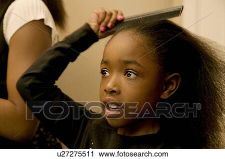 Stock Image - Girl combing hair. Fotosearch