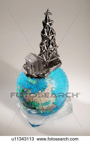 Stock Image - Globe in ice with oil drilling rig. Fotosearch