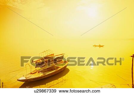Sun shining on a boat on the Ganges river, India View Large Photo Image Stock Photo - Sun shining on a boat on the Ganges river, India. Fotosearch