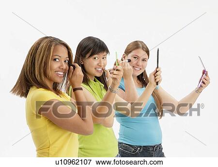 Three teens applying make up View Large Photo Image Stock Photo - Three teens applying make up. Fotosearch