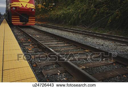 Train on the tracks by a platform View Large Photo Image Stock Image - Train on the tracks by a platform. Fotosearch