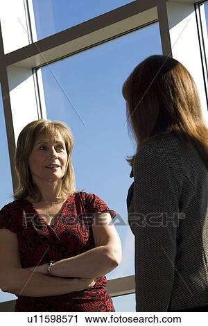 Stock Image - Two women talking. Fotosearch