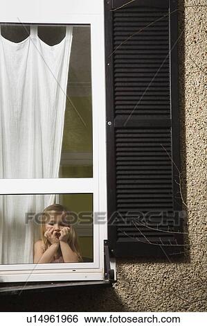 A girl looking out a window View Large Photo Image Stock Photograph - A girl looking out a window. Fotosearch