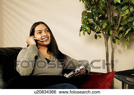 Stock Photograph - A woman working at home. Fotosearch