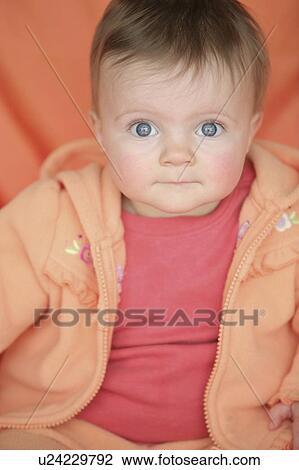 Stock Image - Baby in orange jacket. Fotosearch