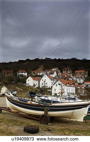 Stock Image - Boat and houses in Runswick, North Yorkshire, England. Fotosearch