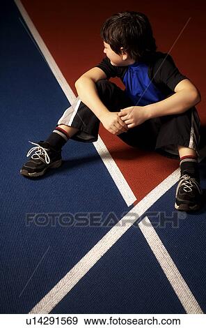 Boy sitting on a race track View Large Photo Image Stock Photo - Boy sitting on a race track. Fotosearch