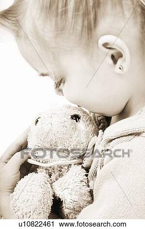 Stock Image - Child holding soft toy. Fotosearch