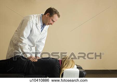 Chiropractor with his patient View Large Photo Image Stock Photograph - Chiropractor with his patient. Fotosearch