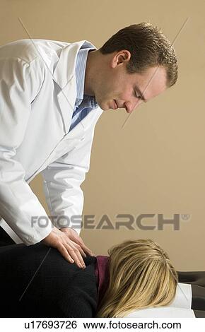 Chiropractor with his patient View Large Photo Image Stock Photograph - Chiropractor with his patient. Fotosearch