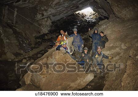 Stock Image - Climbers cheering in cave, Cadomin, Alberta, Canada. Fotosearch