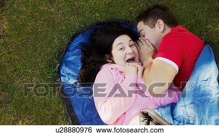 Stock Photograph - Couple in a sleeping bag. Fotosearch