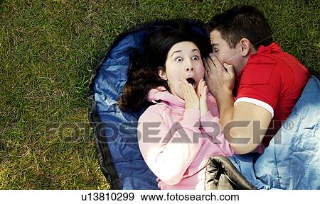 Stock Photo - Couple sharing a secret. Fotosearch