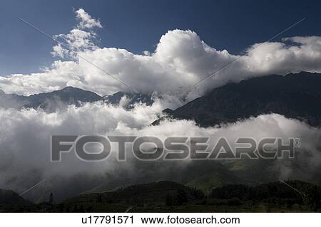 Stock Image - Dramatic clouds form in the mountains near Sapa, Vietnam. Fotosearch