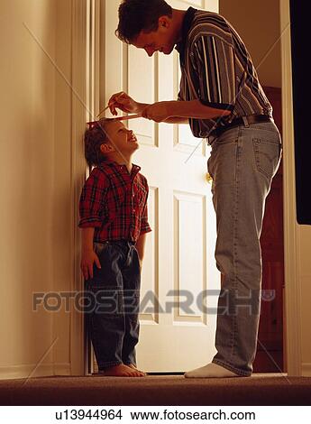 Father measuring son on door frame View Large Photo Image Picture - Father measuring son on door frame. Fotosearch