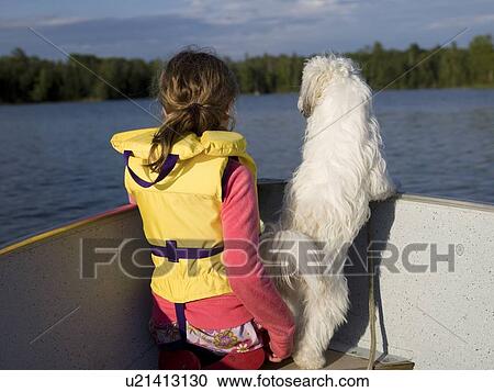 Stock Image - Girl and dog on a boat. Fotosearch