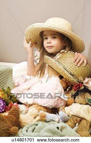 Stock Image - Girl and teddy bear wearing straw hats. Fotosearch