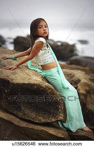 Stock Photograph - Girl leaning on a large rock. Fotosearch