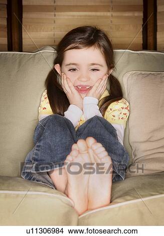Girl sitting on a couch View Large Photo Image Picture - Girl sitting on a couch. Fotosearch