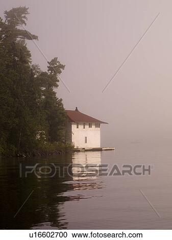 Stock Image - Lake of the Woods, Ontario, Canada, Cottage beside a lake. Fotosearch