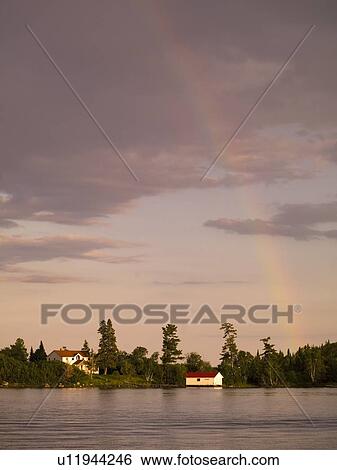 Stock Photograph - Lake of the Woods, Ontario, Canada, rainbow over a lake. Fotosearch