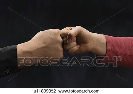 Stock Image - Man And woman friendly knocking fists. Fotosearch