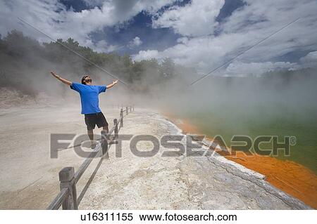 Man at Champagne Pool at geothermal site, Wai-O-Tapu Thermal Wonderland on North Island of New Zealand View Large Photo Image Stock Photography - Man at Champagne Pool at geothermal site, Wai-O-Tapu Thermal Wonderland on North Island of New Zealand. Fotosearch
