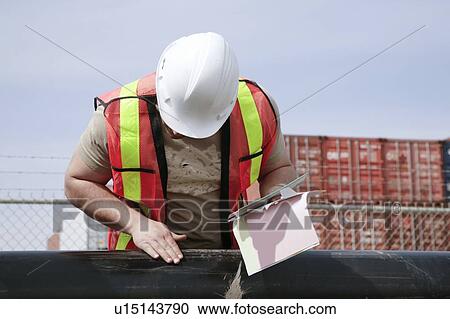 Man inspecting pipe View Large Photo Image Stock Image - Man inspecting pipe. Fotosearch