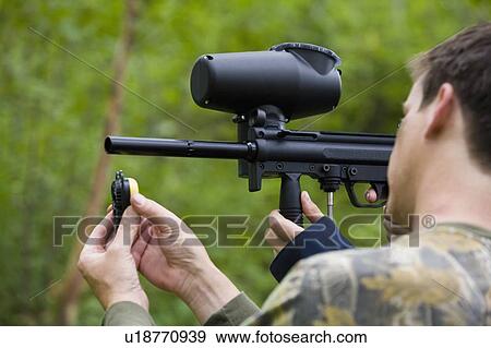 Man loading paintball gun View Large Photo Image Stock Photo - Man loading paintball gun. Fotosearch