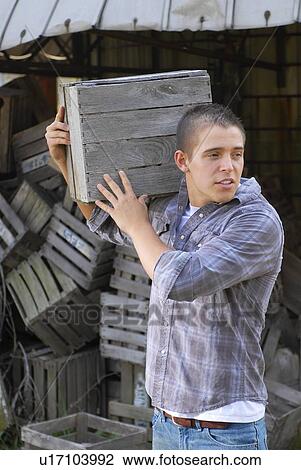 Stock Image - Man moving wooden crate. Fotosearch