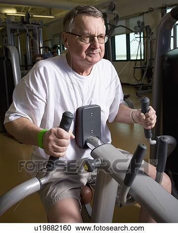 Stock Image - Man on a workout machine. Fotosearch