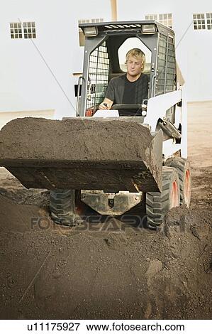 Stock Photo - Man operating small digger. Fotosearch