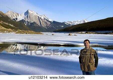 Man standing in front of Medicine Lake, Alberta, Canada View Large Photo Image Picture - Man standing in front of Medicine Lake, Alberta, Canada. Fotosearch