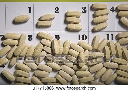 Stock Photograph - Pills scattered on a calendar page. Fotosearch
