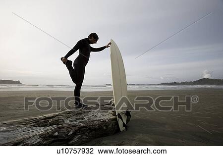 Surfer stretching on beach View Large Photo Image Stock Image - Surfer stretching on beach. Fotosearch