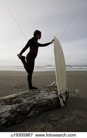 Surfer stretching on beach View Large Photo Image Stock Photo - Surfer stretching on beach. Fotosearch