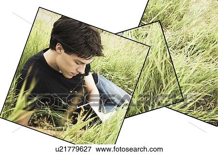 Stock Photo - Teenage boy reading in the grass. Fotosearch