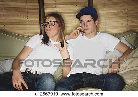 Stock Photo - Two people sitting on a couch. Fotosearch