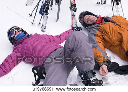 Stock Image - Two skiers resting in the snow, Whistler, BC, Canada. Fotosearch