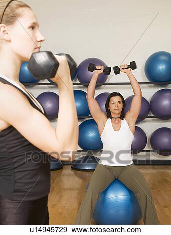 Two women exercising View Large Photo Image Stock Photo - Two women exercising. Fotosearch