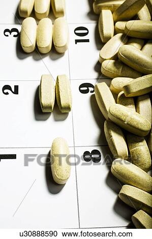 Stock Image - Vitamins Divided On A Calendar Page. Fotosearch