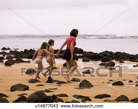 Stock Image - Walking along a beach in Kauai, Hawaii, USA. Fotosearch