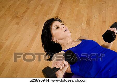 Picture - Woman at a gym working out. Fotosearch