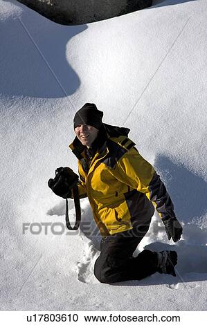 Woman kneeling in the snow holding a camera, Jasper National Park, Alberta, Canada View Large Photo Image Stock Image - Woman kneeling in the snow holding a camera, Jasper National Park, Alberta, Canada. Fotosearch