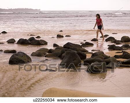 Woman walking along the beach, Kauai, Hawaii, USA View Large Photo Image Picture - Woman walking along the beach, Kauai, Hawaii, USA. Fotosearch