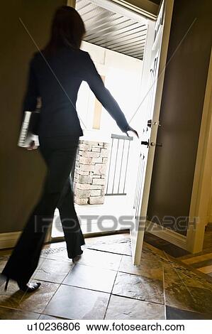 Stock Photograph - Woman walking out a door. Fotosearch