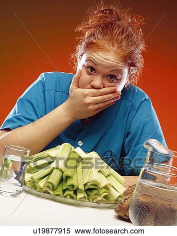 Stock Photography - Woman with plate of celery and sports equipment. Fotosearch