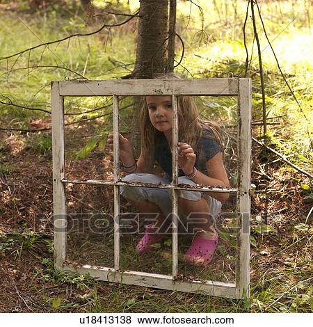 Young girl in woods, looking through old window View Large Photo Image Stock Photo - Young girl in woods, looking through old window. Fotosearch
